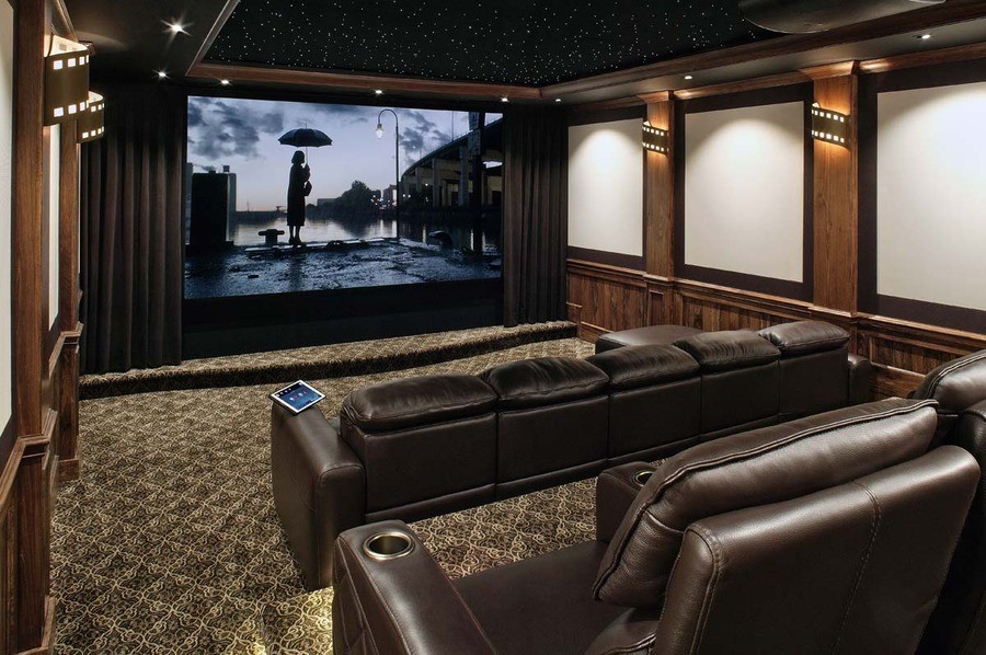 A custom home theater with a large screen, projector, and comfortable seating. 